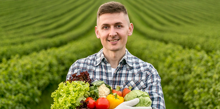 Organic farmer holding fresh vegetables
